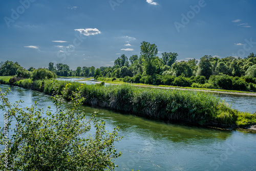 Grünes Ufer und ruhiger Fluss bei strahlendem Wetter in einem ländlichen Gebiet