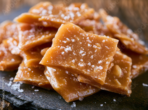 A mound of toasted, crispy, salted bits of amber candy. A delectable sweet, crunchy snack studded with nuts. A scrumptious delight for dessert enthusiasts.
