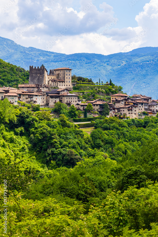 Obraz premium Tenno Castle standing on a rocky spur with its small medieval village at its foot in spring, Trentino