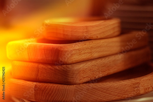 Wooden trays stacked on a table next to ceramic plates in a kitchen setting