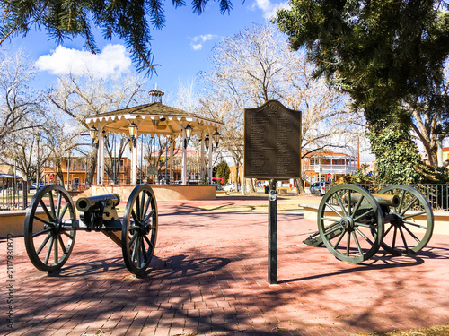 View of historic Old Town Albuquerque Plaza at sunrise showing brick walkways, historic cannon, and gazebo