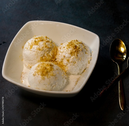 Canvastavla Bowl with tasty vanilla ice cream on a dark background
