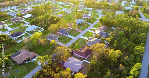 High angle view of North Port residential community at sunset with private homes, green yards and organized streets, capturing suburban sprawl, wealth, and housing market growth in the USA.