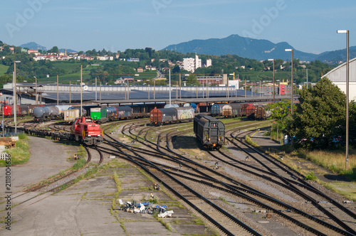 Red freight locomotive moving on tracks in Chiasso railway marshalling yard