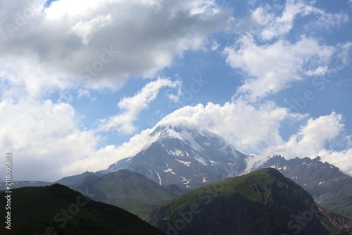 Scenic view of Mount Kazbegi snow capped summit with dramatic cloudscape in Greater Caucasus