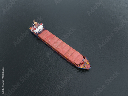 Obraz na płótnie Aerial top down drone view of a general cargo ship sailing in the calm dark blue