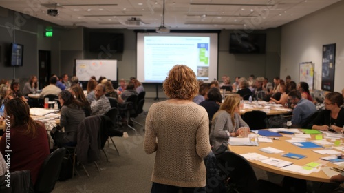 Trainer facilitating soft skills development workshop highlighting teamwork and emotional intelligence with projector slides and handouts in focus.