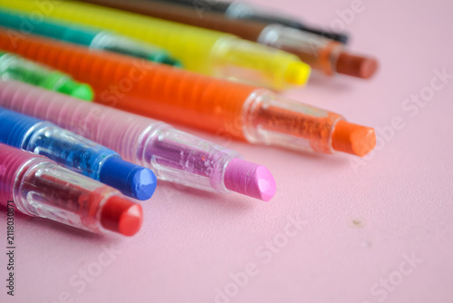 Back to school colorful twistable crayons and wax crayons on pink background