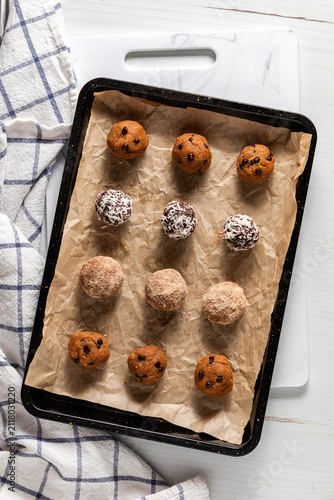 A parchment lined baking tray topped with various kinds of energy balls.
