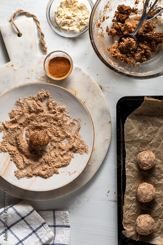 Process image depicting rolling an energy ball in protein powder and cinnamon.