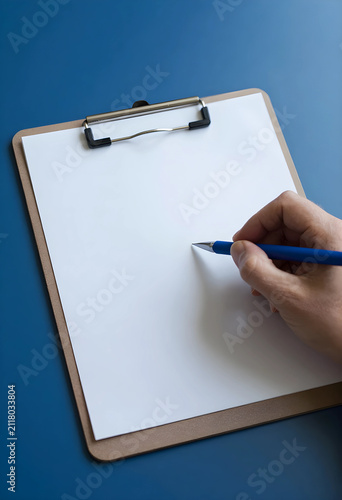 Hand holding a blue pen ove...