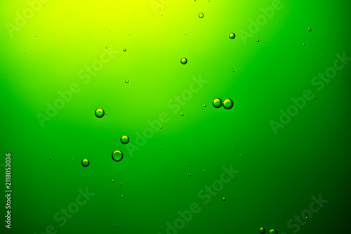 Fotografie Green liquid with rising bubbles creating abstract background