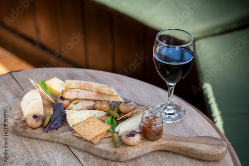 Enjoying a Delightful Cheese Platter and Wine on a Cozy Wooden Table