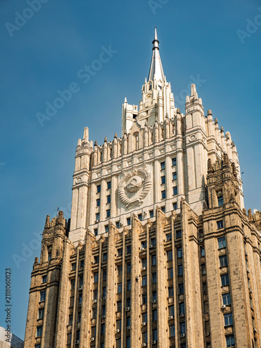 Ministry of Foreign Affairs of Russia building in Moscow, Stalinist architecture skyscraper with Soviet emblem against a blue sky.