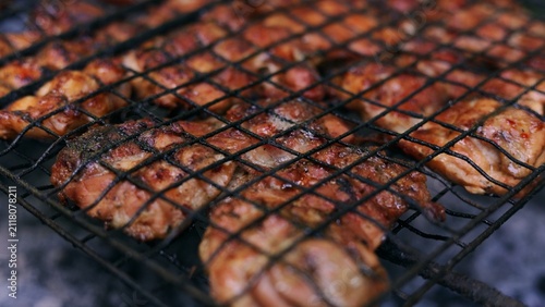 Fotografía Juicy chicken pieces sizzling and browning on a hot metal grill grate outdoors