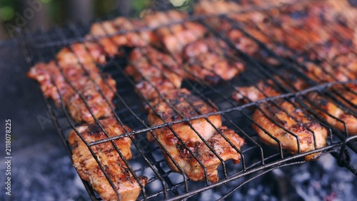 Fotografía Juicy chicken pieces sizzling on a hot barbecue grill outdoors