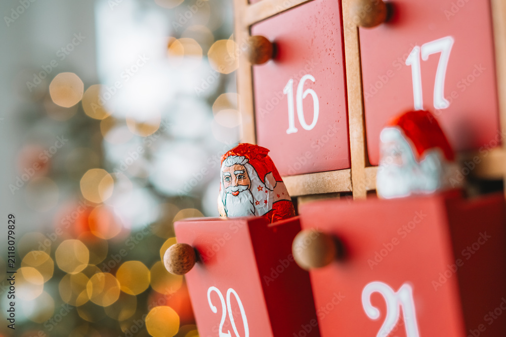 Obraz premium Wooden Christmas Advent Calendar with Chocolate Santa.cozy holiday atmosphere for Advent countdown,Christmas traditions,family celebrations,holiday promotions, seasonal blog