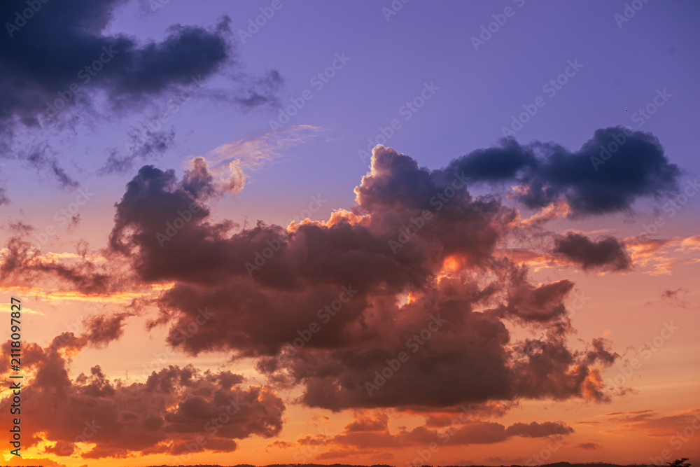 Fototapeta premium Dramatic Purple and Orange Sunset Clouds Across the Evening Sky