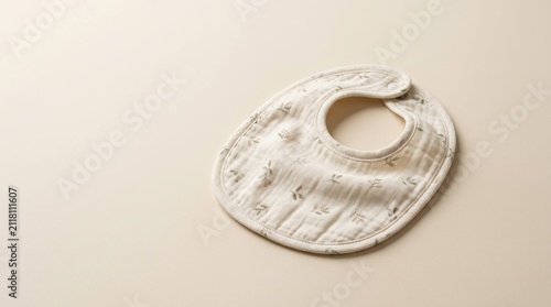 White Cotton Baby Bib with Minimalist Botanical Pattern on Soft Cream Background
