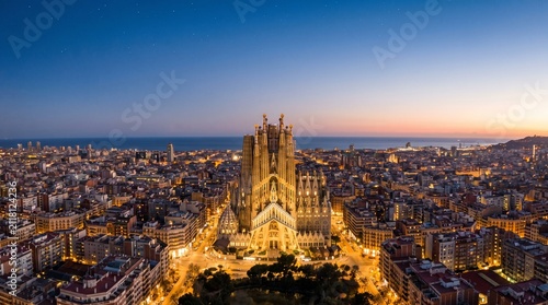 Aerial view of Barcelona city at sunset. Famous cathedral illuminated in urban landscape.