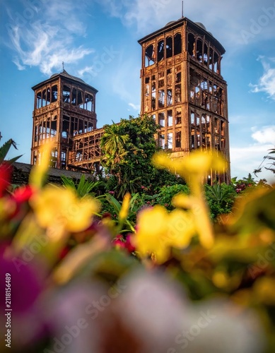 Ancient stone tower ruins behind yellow flowers.