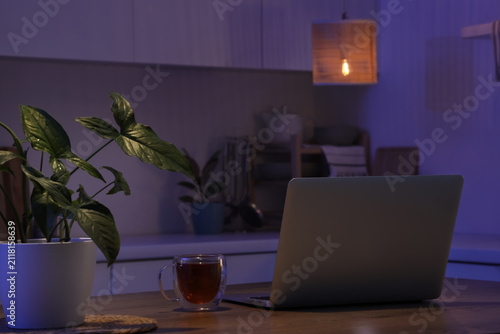 Laptop and hot tea on a woo...