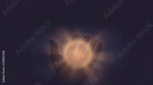 hand silhouette with glowing light representing healing touch concept