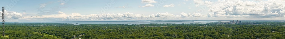 Fototapeta premium Panoramic view of city skyline by lake surrounded by forest