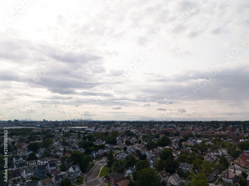 Cuadro en lienzo Aerial drone view of distant city skyline beyond a wooded suburban landscape in