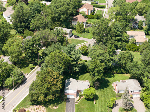 Aerial drone view of tree-lined residential neighborhood with detached homes and local streets in Bayberry Park, New Rochelle, New York
