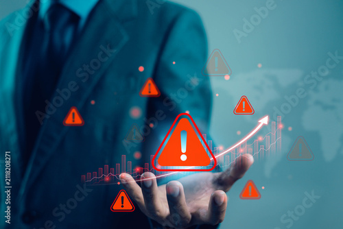 Businessman presenting financial risk warning with alert icons and rising chart, representing risk management, business uncertainty, investment volatility, compliance, crisis prevention.