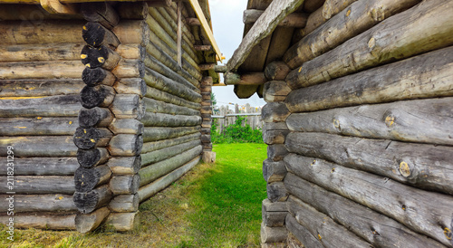 Obraz na plátně Ancient Log Cabins Under Stormy Skies