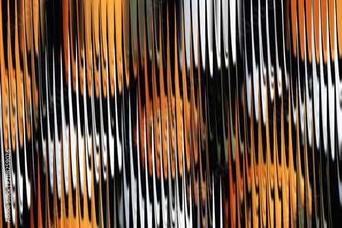 Abstract patterned background with orange and black stripes suggesting movement and texture during daylight