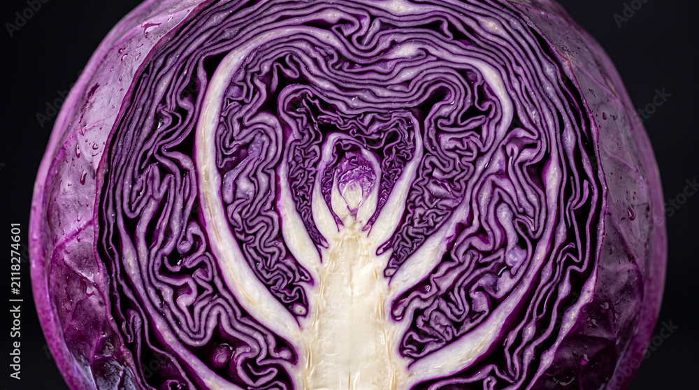 Obraz premium Fresh red cabbage cross section. Close up of organic vegetable texture on black background.