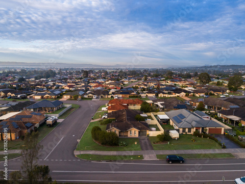 Dawn scene overlooking houses and rooftops of homes along street in Australian suburb