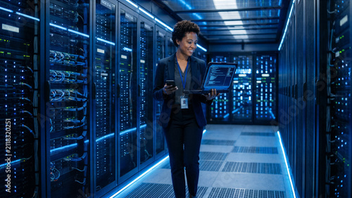 Confident cybersecurity expert walking through a modern high-tech server room with glowing blue LED lights
