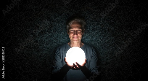 Woman holding glowing orb in darkness concept of light and mystery