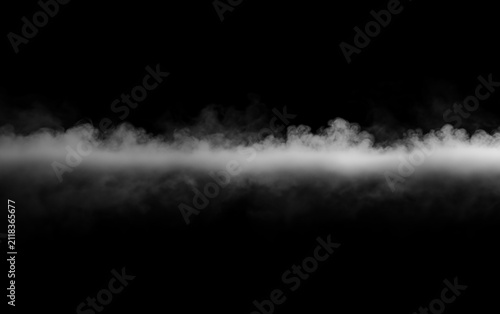 Low lying dense white smoke line spreading horizontally on black background for ground fog effect. Solid layer of thick vapor mist crawling across dark empty space floor surface.