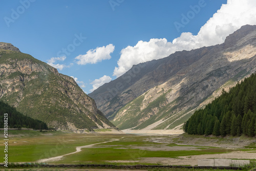 Obraz na płótnie Dried shoreline of Livigno Lake revealing exposed ground after prolonged summer heat in the alpine mountains