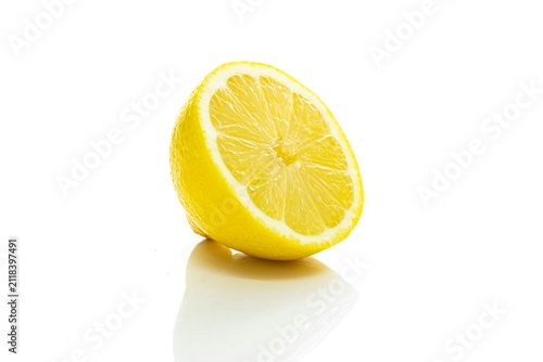 Foto Fresh half of yellow lemon on white background with reflective surface