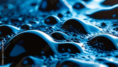 Blue liquid ripples with glossy, rounded droplets