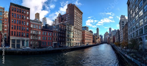 Urban Riverfront Panorama - A Serene View of City Architecture and Waterway.