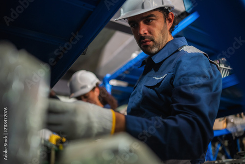 Chief mechanical engineer inspecting examining circuit board motherboard spare parts stock room factory. Concept of industrial maintenance service inspecting management and managing industrial waste.