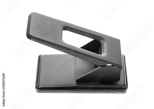 Black metal hole puncher isolated on neutral gray background.