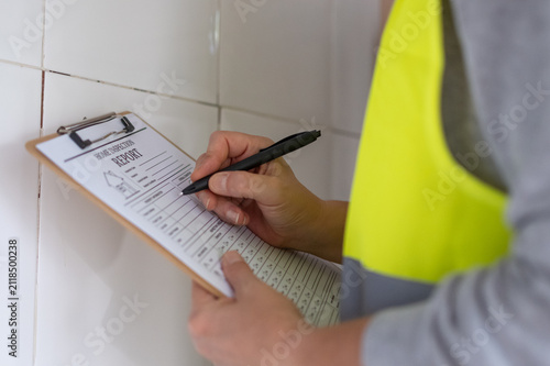 Foto Professional home inspector wearing a safety vest and holding a clipboard with a