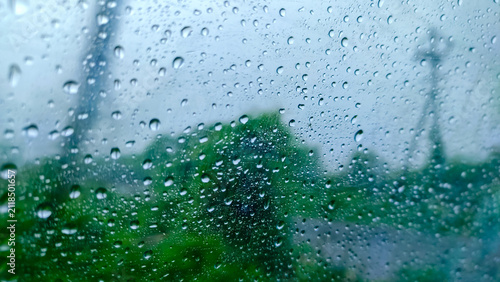 rain drops on a glass of the window of the car in the rainy season.