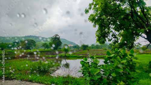 rain drops on a glass of the window of the car in the rainy season.