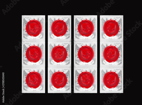 Grid of red prophylactic items in square foil blister packages.