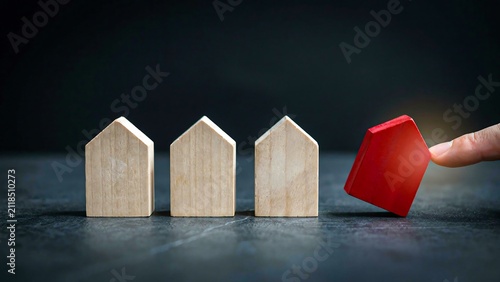 Wooden house models with red home showing real estate market change concept