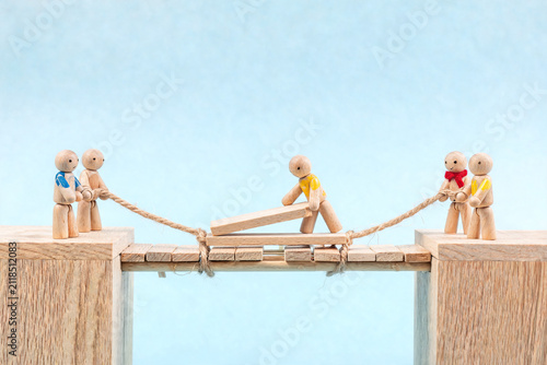 Wooden Figures Building a Bridge Together
